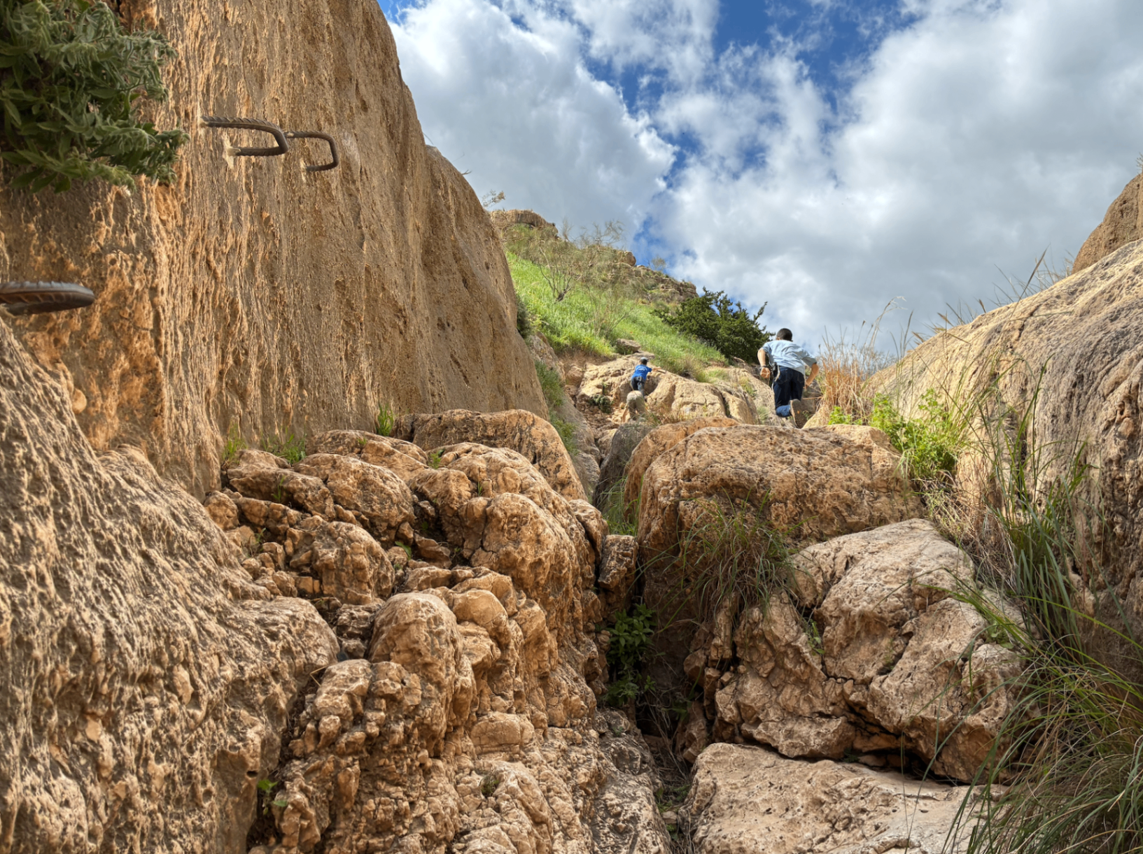 Father and son climbing through a desert canyon in Israel